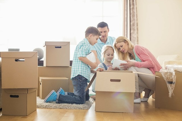 Family unpacking moving boxes in their new home.