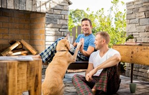 A couple sitting on a patio with dog