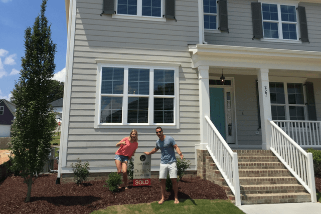 young couple outside new home