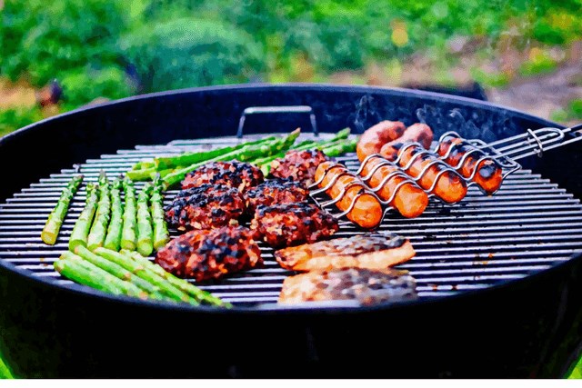 Outdoor grill with steaks and asparagus