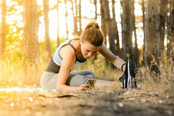 woman stretching on trail