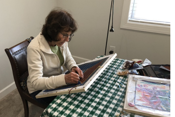 woman doing details needlepoint