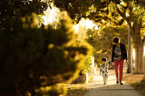 Parent and child walking along sidewalk