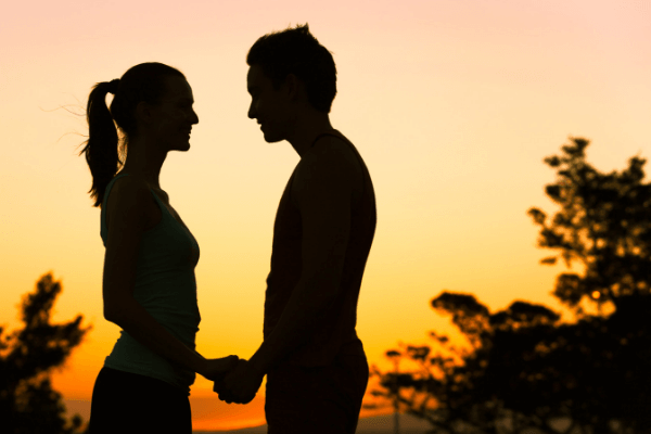 couple holding hands at sunset