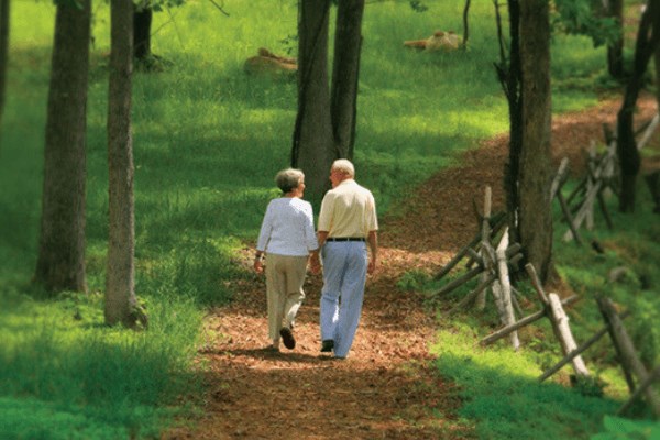 Older couple walking along wooded trail in Briar Chapel