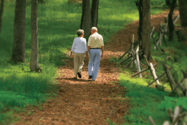couple talking a walk along wooded trail