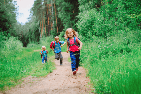 kids running along wooded trail