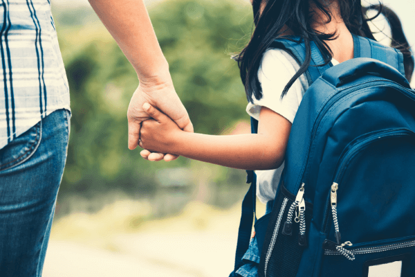 adult and kid walking to school