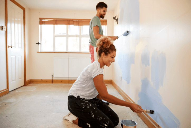 couple painting bedroom wall